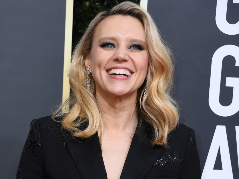 Kate McKinnon laughing while wearing a black blazer