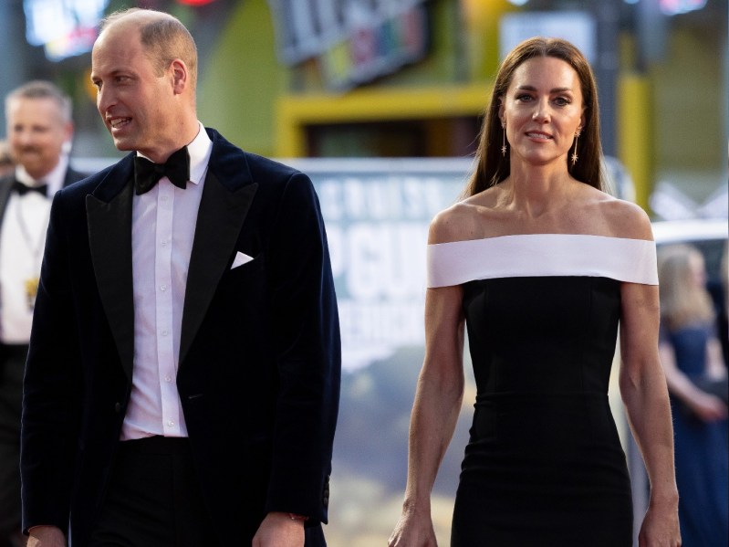 Prince William, in a black and white suit, walks with wife Kate Middleton, in a black and white dress, on the Top Gun: Maverick red carpet