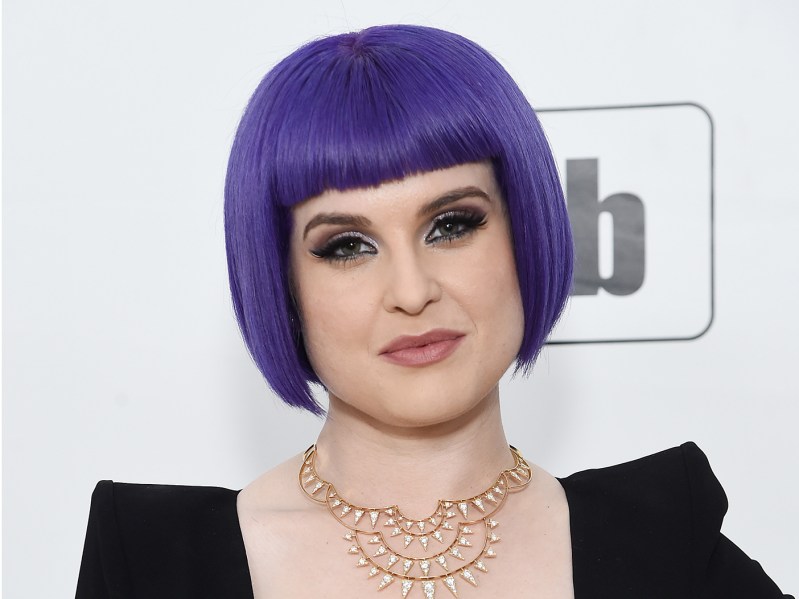 kelly osbourne smiling with purple hair in a black dress
