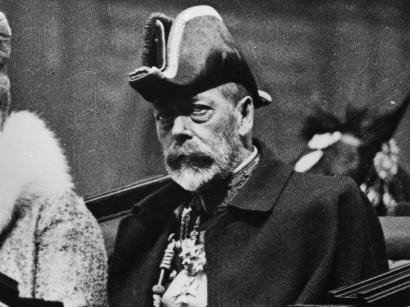 Black and white photo of King George V wearing royal garb and hat