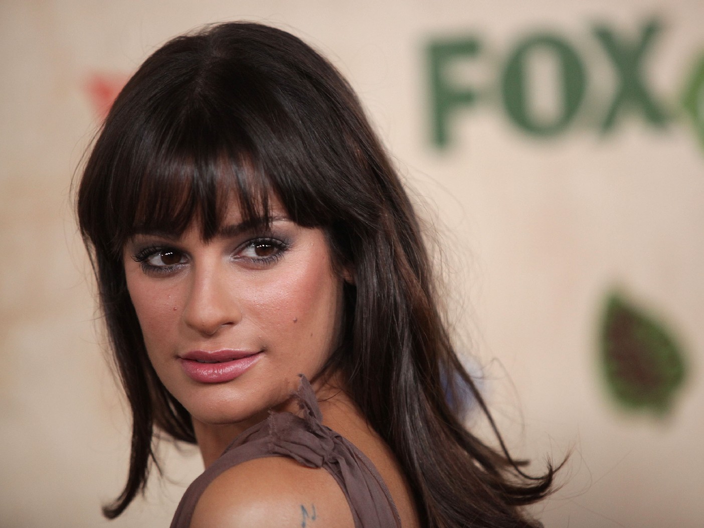 Lea Michele looks over her shoulder on the red carpet