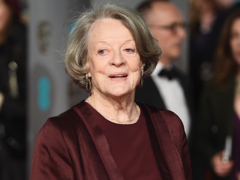 Maggie Smith wears a russet colored suit on the red carpet