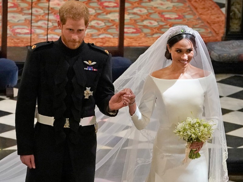 Prince Harry holds Meghan Markle's hand as they walk down the aisle during their 2018 wedding
