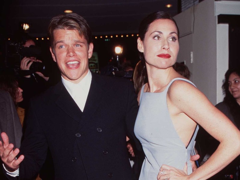 Matt Damon (L) in white top and black jacket, next to Minnie Driver (R) wearing pale grey tank dress