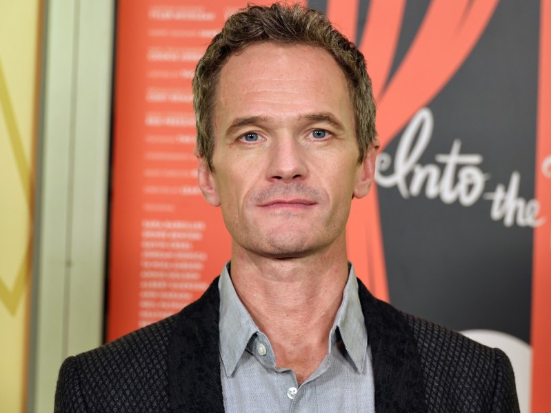 A straight-faced Neil Patrick Harris is wearing a grey shirt and black suit jacket.