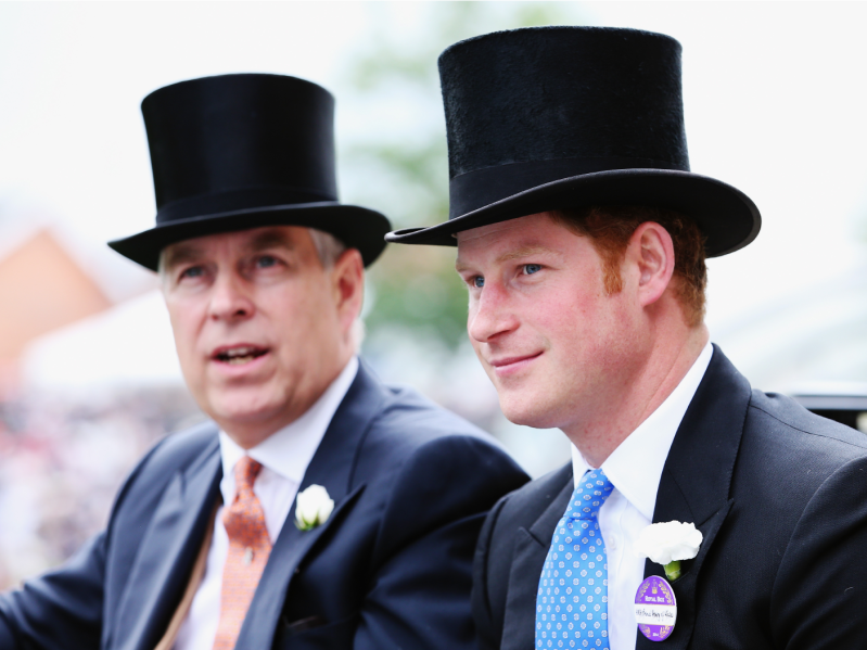 Prince Andrew (L) and Prince Harry (R) wearing top hats and suit/tie ensembles, speaking and riding in a car