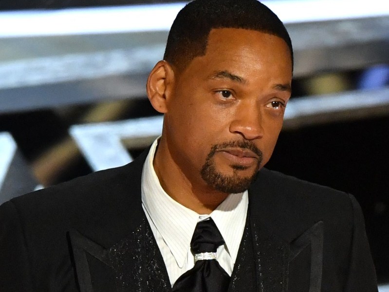 Will Smith tearfully accepts an Oscar after slapping Chris Rock while wearing a black tux