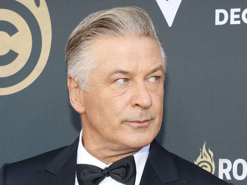 Alec Baldwin wears a black suit and tie on the red carpet