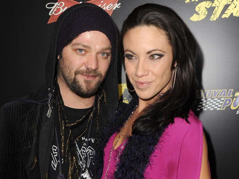 Bam Margera (L) wearing black jacket with hood up, standing next to Nicole Boyd, who is wearing a hot pink shirt