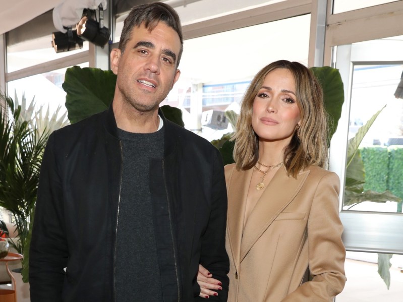 Bobby Cannavale (L) wearing all-black outfit and Rose Byrne wearing tan pantsuit
