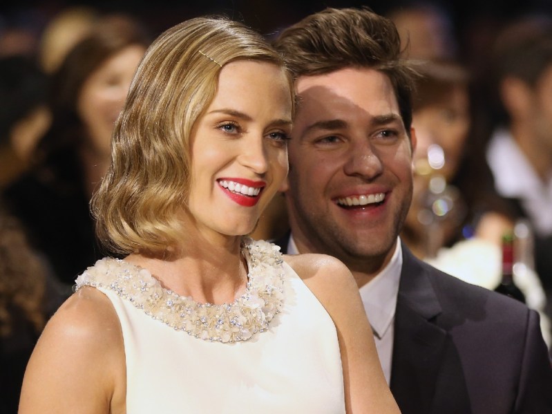 Emily Blunt wears a white dress and sits in husband John Krasinski's lap at an awards show