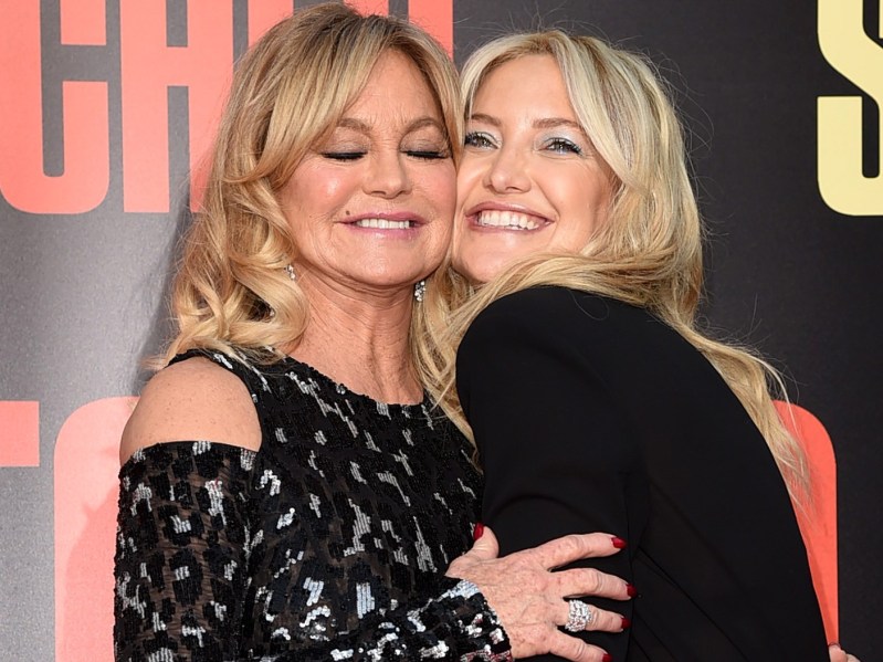 Goldie Hawn (L) wearing leopard print dress and Kate Hudson wearing black top