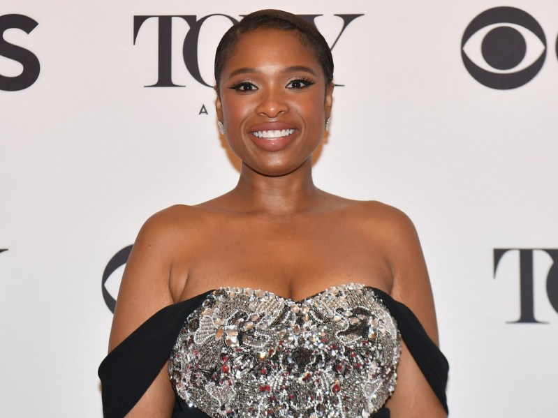 Jennifer Hudson smiles while wearing silver and black gown