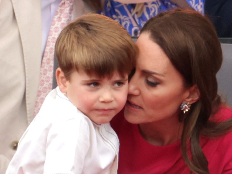 Prince Louis sits closely with his mother Kate Middleton during the Jubilee parade