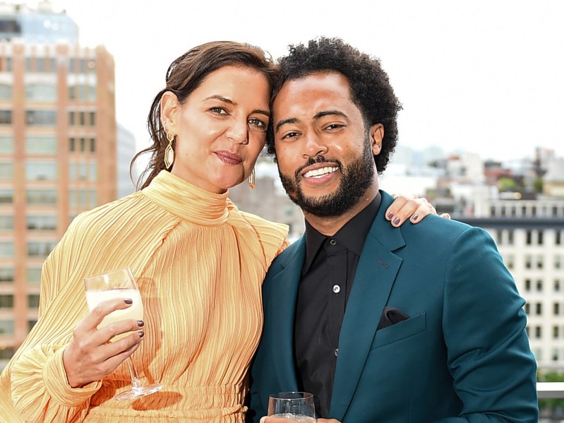 Katie Holmes (L) wearing yellow dress and Bobby Wooten III (R) wearing teal suit jacket over black shirt