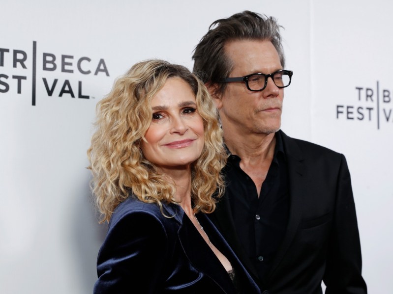 Kyra Sedgwick wears a velvet blue top alongside husband Kevin Bacon, in a black suit, on the red carpet