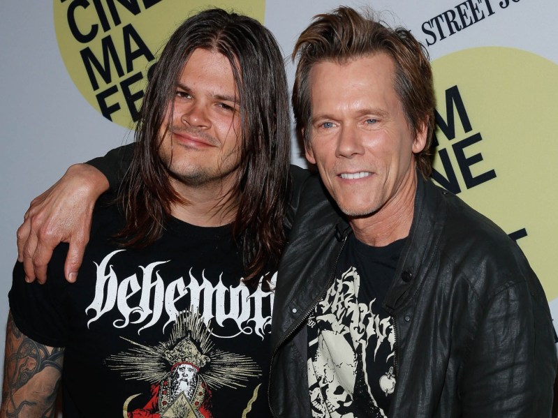 Travis Bacon (L) wearing cutoff black tank top, with Kevin Bacon wearing leather jacket over black shirt