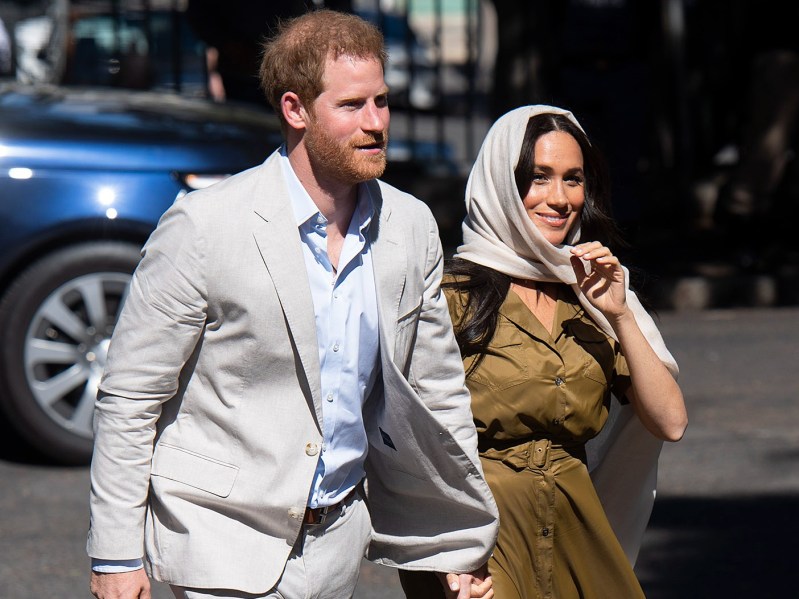 (Prince Harry (L) wearing khaki suit and Meghan Markle (R) wearing olive green dress and headwrap