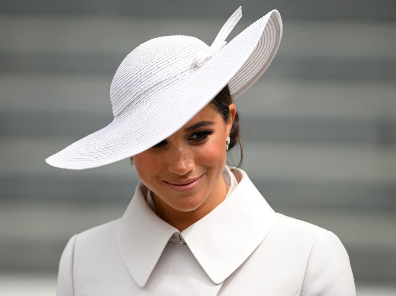 meghan markle smiling in a white dress and hat