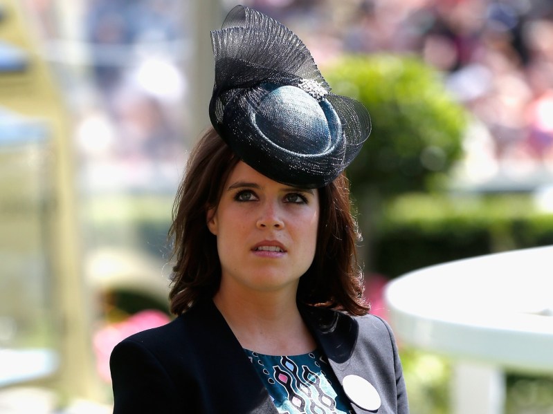 Princess Eugenie looks up at the sky while wearing ornate black hat