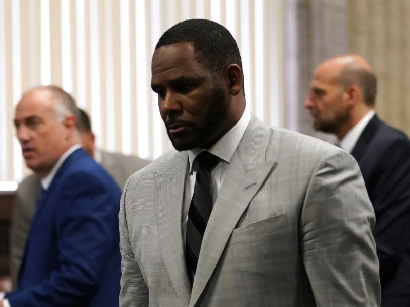 R. Kelly walks out of court while wearing a gray suit and black tie
