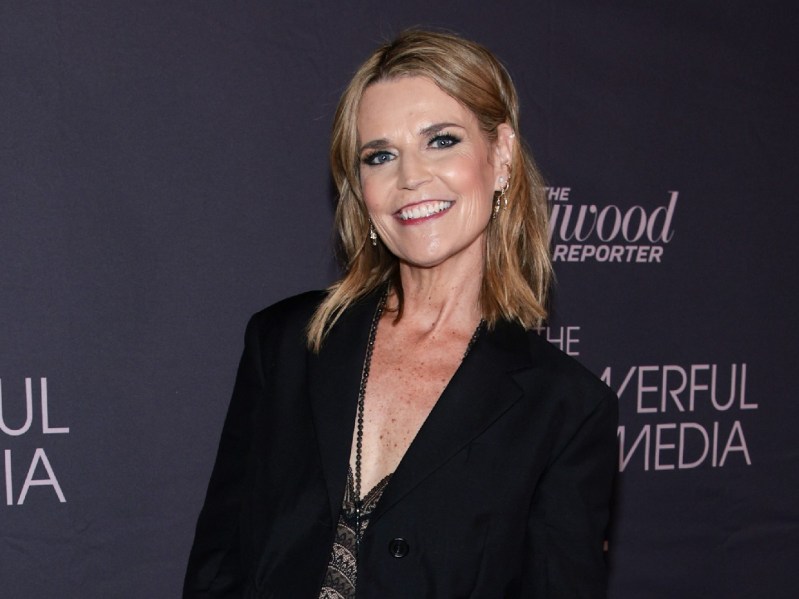 Savannah Guthrie wears a black jacket over a dark and blue dress on the red carpet