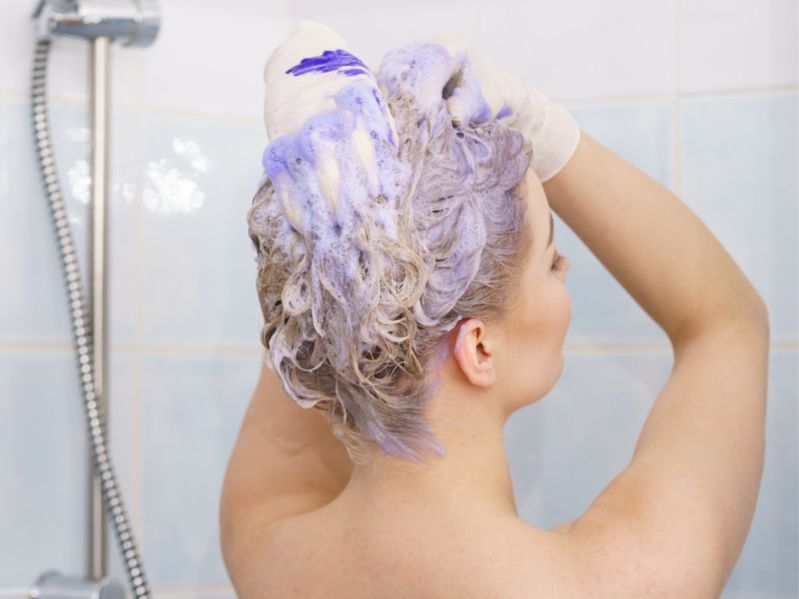Woman washing hair with purple shampoo