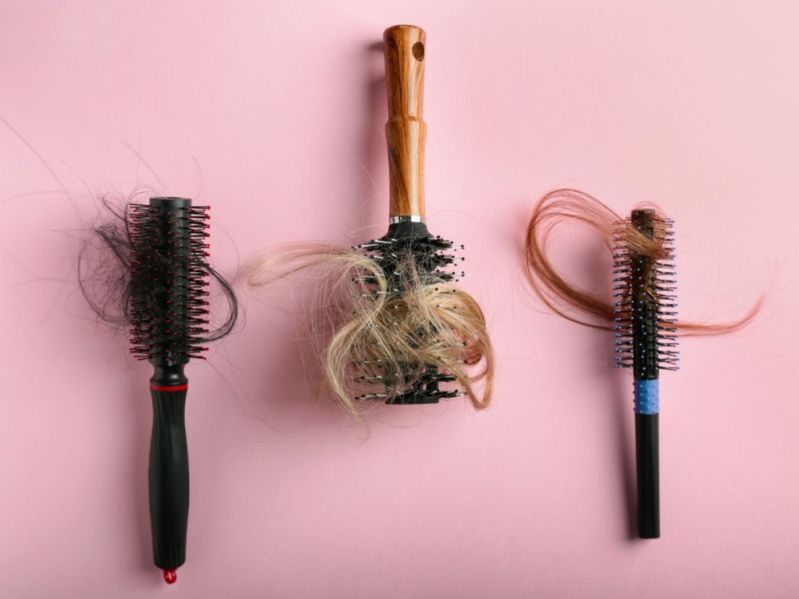 Brushes with locks of hair tangled in bristles
