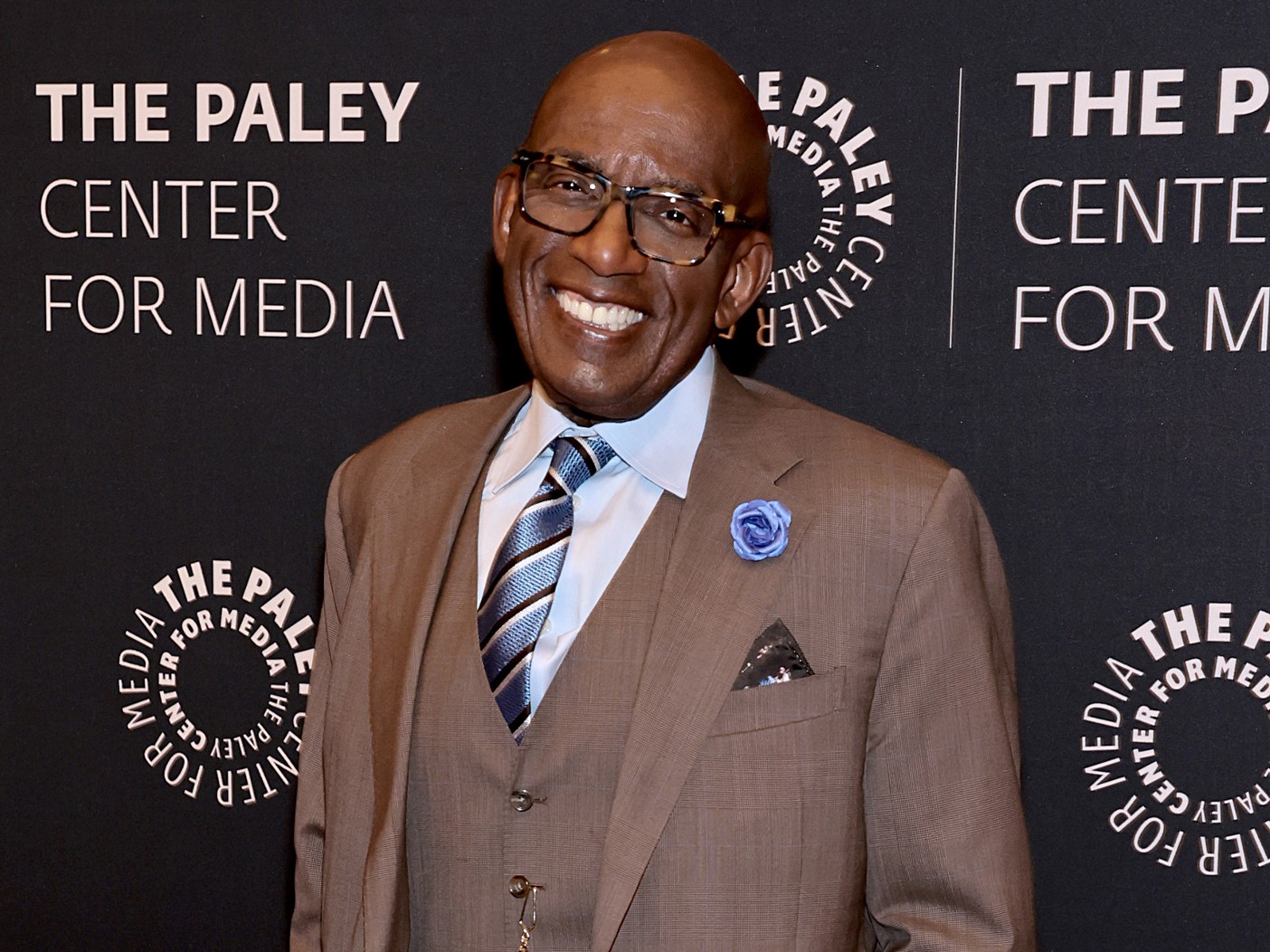 Smiling Al Roker wearing brown suit and blue tie