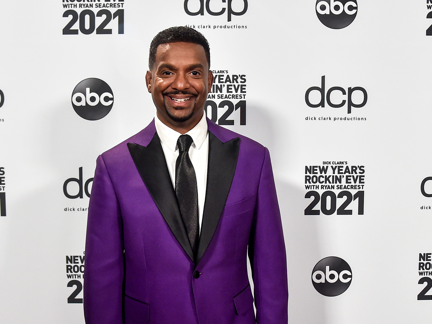 Alfonso Ribeiro smiling in a purple tuxedo