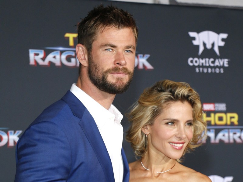 Chris Hemsworth (L) wears dark blue blazer over white dress shirt, standing next for to Elsa Pataky, who can be seen from the shoulders up
