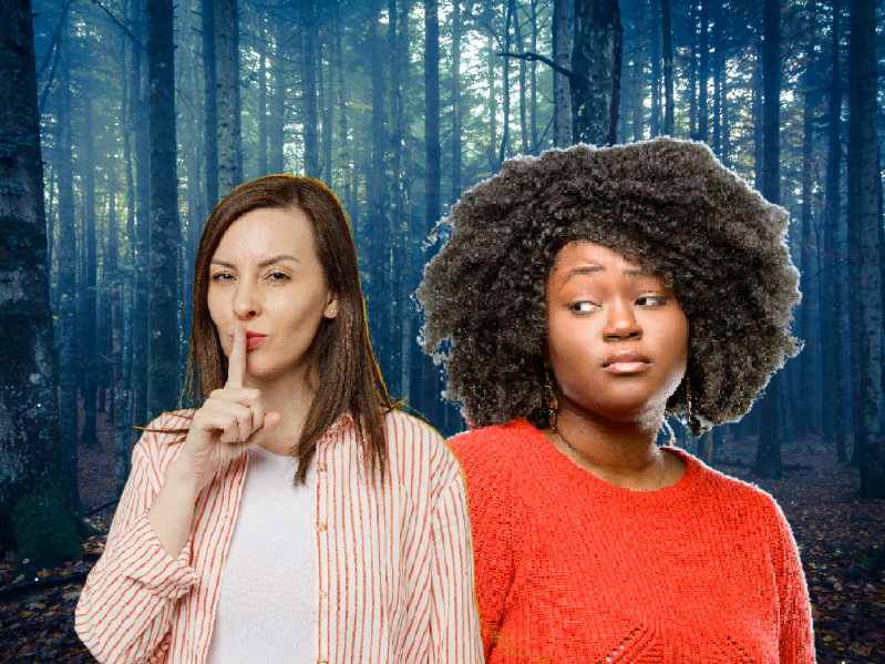 Two women, one white one black, are positioned in front of a photo of the woods. The white woman holds one finger to her lips while the black woman looks at her suspiciously