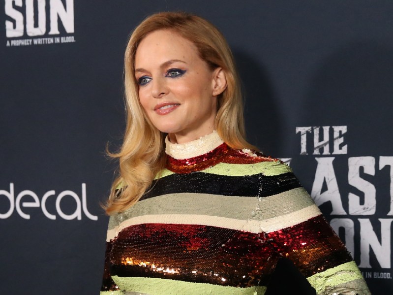 Heather Graham wearing striped dress against charcoal backdrop