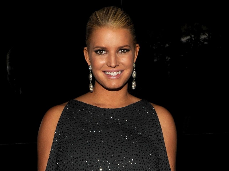 Jessica Simpson smiles in sparkly black dress against deep black backdrop