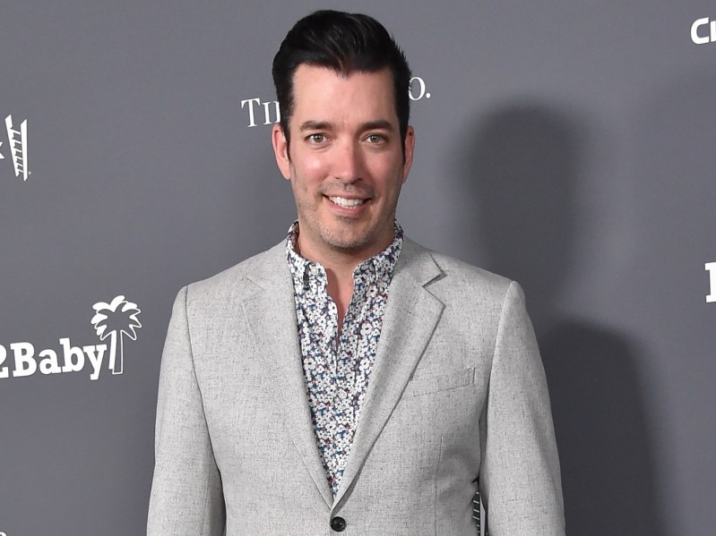 Jonathan Scott smiles in gray suit against slightly darker gray backdrop