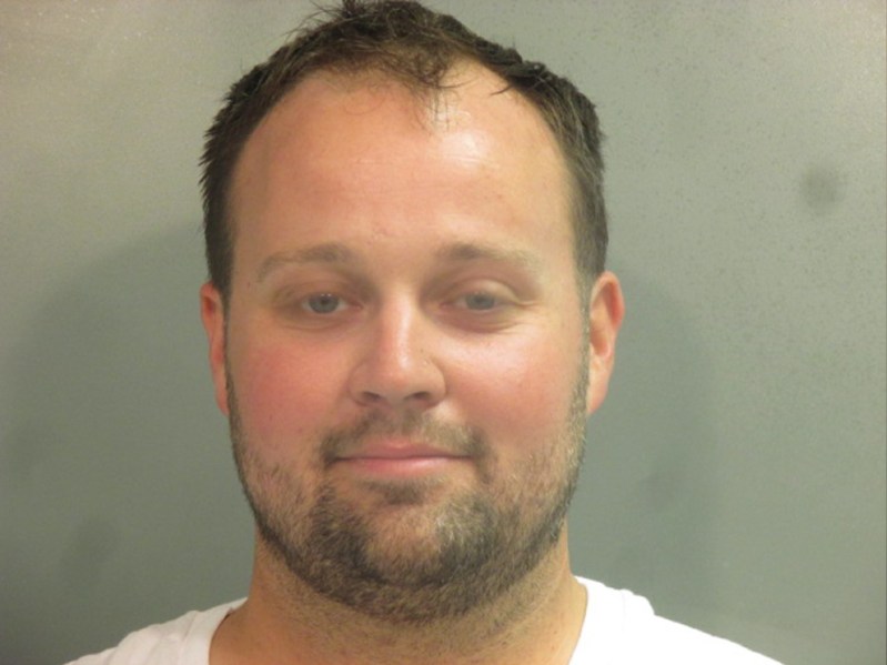 Josh Duggar wears a white t shirt as he poses for a mug shot