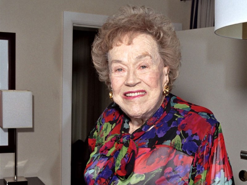 Julia Child wears a brightly patterned blouse indoors