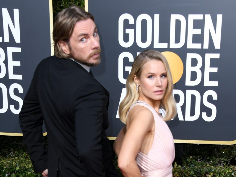 Dax Shepard (L) wearing suit and Kristen Bell wearing pink gown on Golden Globes red carpet