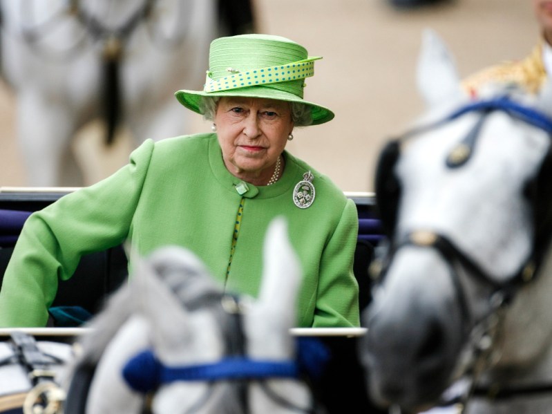 Queen Elizabeth wears green while sitting in an open carriage