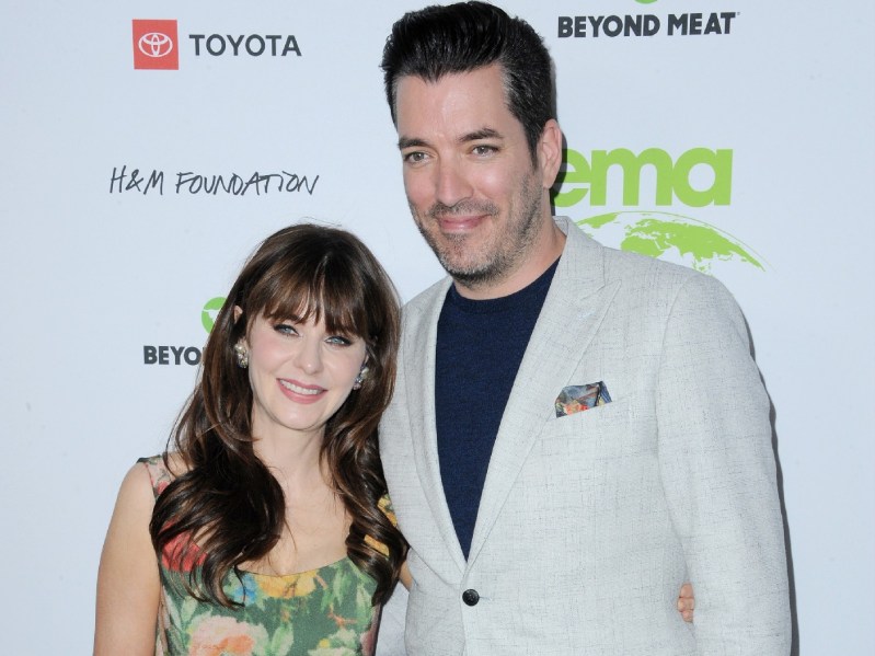 Zooey Deschanel wears a floral gown alongside Jonathan Scott in a light suit jacket on the red carpet
