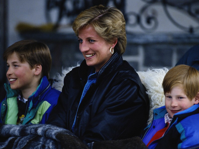 Princess Diana smiling with a young Prince William on her right and a young Prince Harry on her left.
