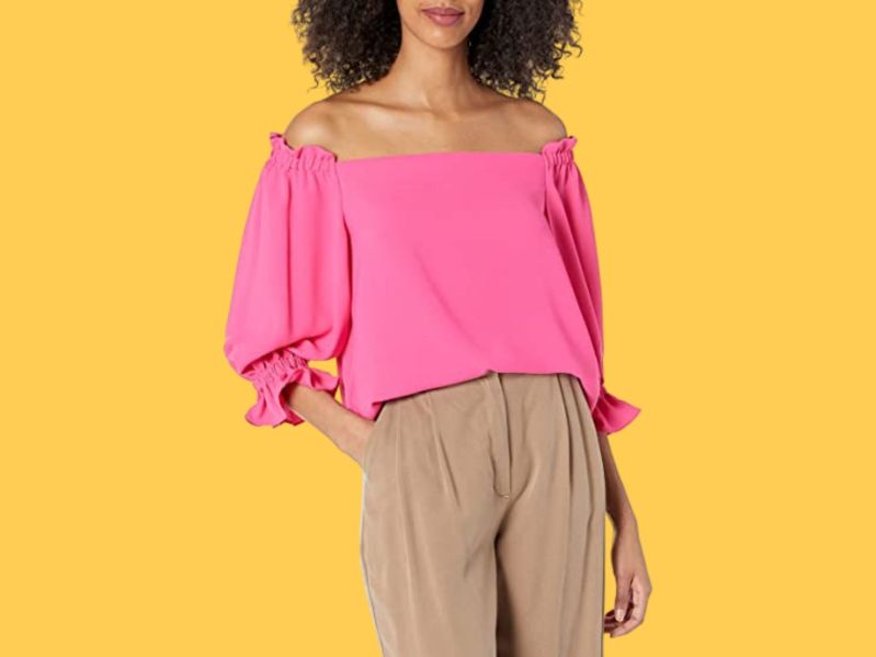 black woman wearing pink off shoulder top and khakis