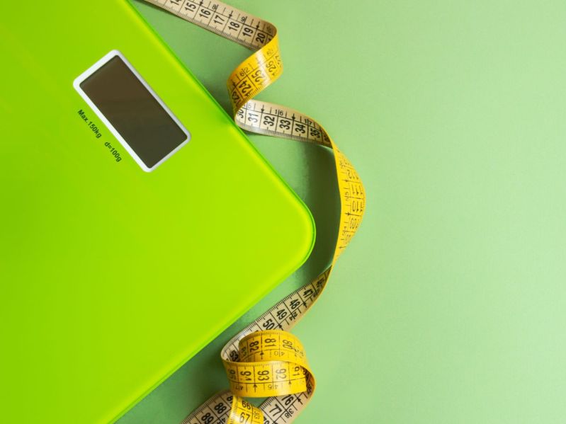 Green scale and yellow tape measure on green background
