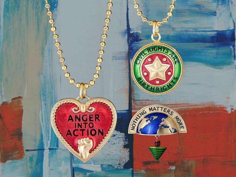 Passionate Protest jewelry: heart necklace that says "Anger into action," circular medallion necklace that says "Civil Rights are Birth Rights," and earth pin that says "Nothing Matters More"
