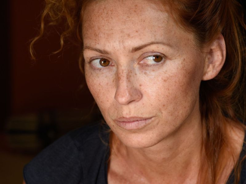 Close up of a midlife woman with a serious, thoughtful expression