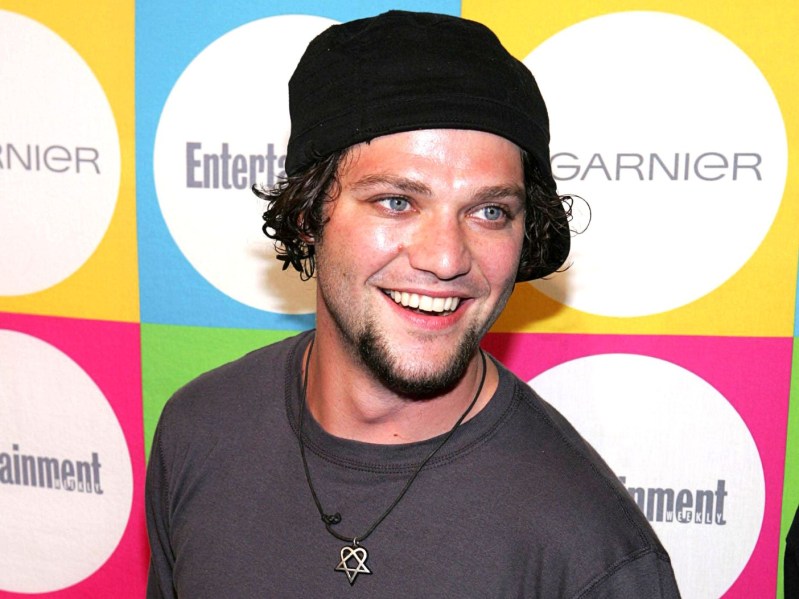 Bam Margera smiles in gray shirt and black beanie
