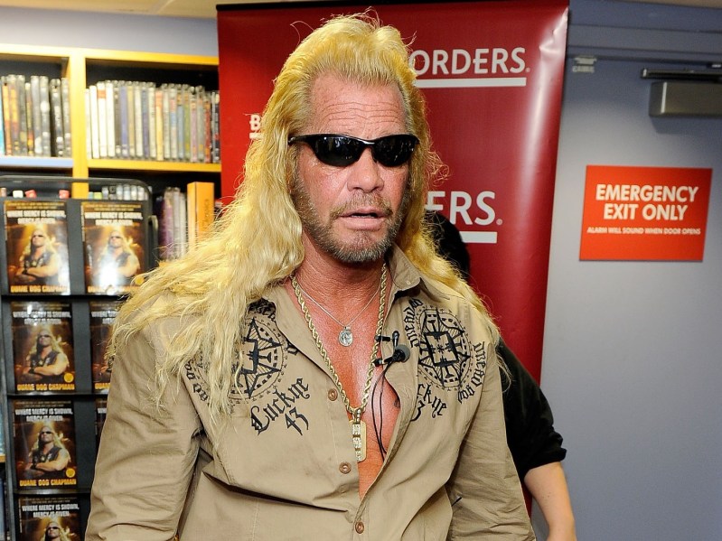 Dog The Bounty Hunter standing in front of a bookcase