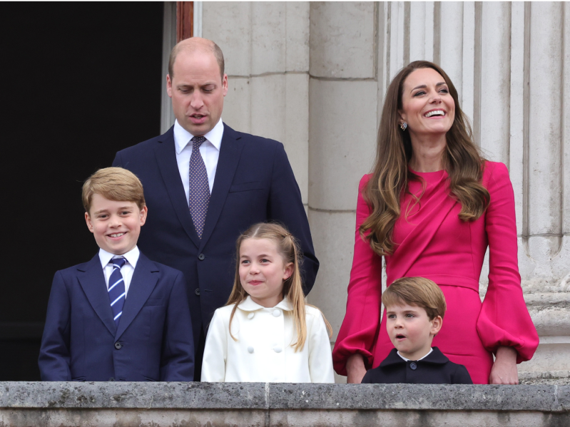 (L-R): Prince George, Prince William, Princess Charlotte, Prince Louis, Kate Middleton smiling off balcony