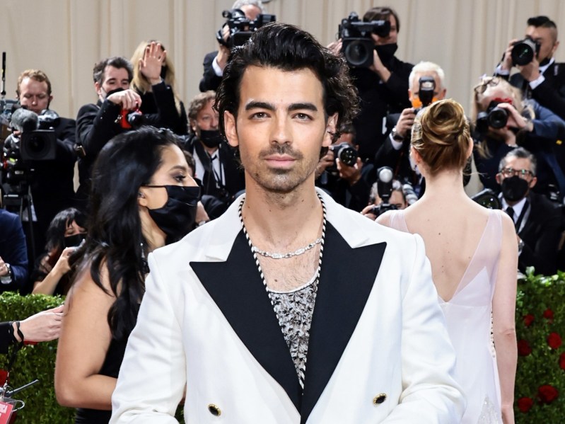 Joe Jonas smiles in white suit with black trim