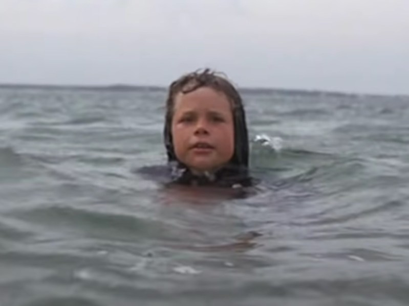 child actor Jonathan Searle with his head bobbing out of the water